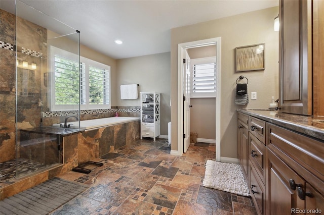 14417 W 57th Pl, Arvada, CO 80002 - bathroom featuring healthy amount of natural light, a tile shower, a bath, stone tile flooring, and recessed lighting