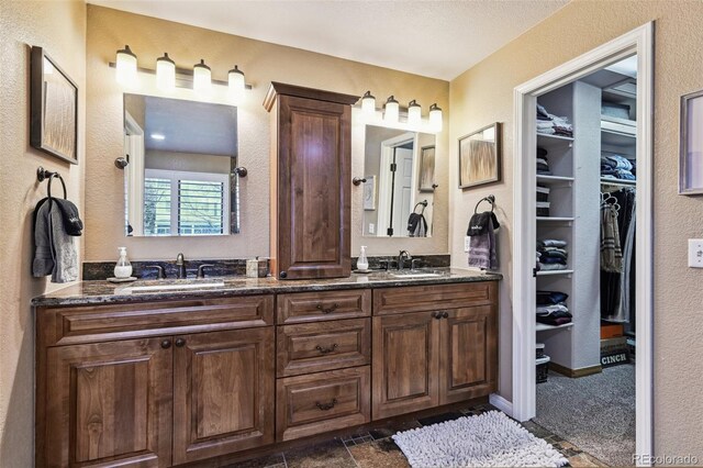 14417 W 57th Pl, Arvada, CO 80002 - bathroom featuring double vanity, a spacious closet, and a textured wall