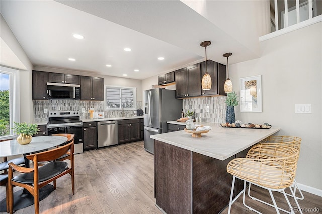 17548 E Wesley Pl, Aurora, CO 80013 - kitchen featuring stainless steel appliances, a peninsula, light wood-type flooring, dark brown cabinetry, and recessed lighting