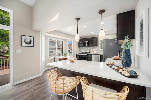 17548 E Wesley Pl, Aurora, CO 80013 - kitchen featuring appliances with stainless steel finishes, a peninsula, light countertops, wood finished floors, and plenty of natural light