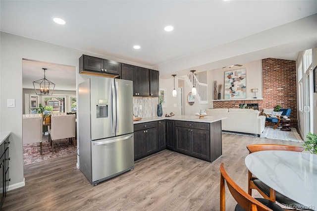 17548 E Wesley Pl, Aurora, CO 80013 - kitchen with stainless steel fridge with ice dispenser, light wood finished floors, a peninsula, light countertops, and brick wall