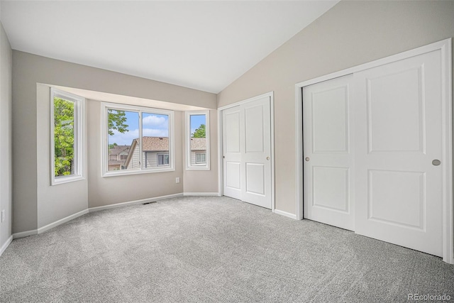 17548 E Wesley Pl, Aurora, CO 80013 - unfurnished bedroom with multiple closets, carpet floors, and lofted ceiling