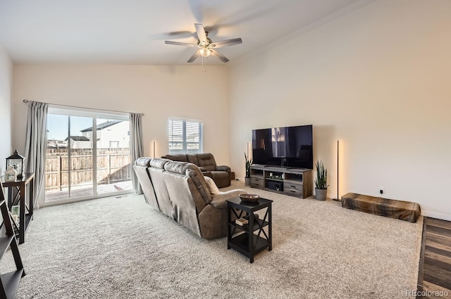 carpeted living room featuring a towering ceiling and ceiling fan