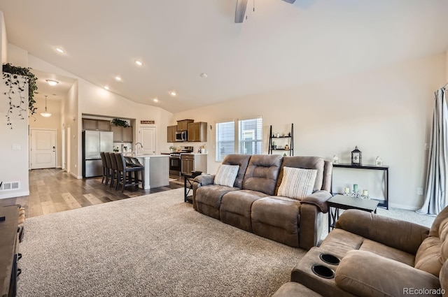 living room with ceiling fan, wood-type flooring, and high vaulted ceiling