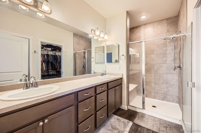 bathroom featuring hardwood / wood-style flooring, vanity, and an enclosed shower