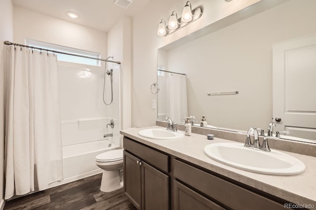 full bathroom with wood-type flooring, vanity, shower / bathtub combination with curtain, and toilet