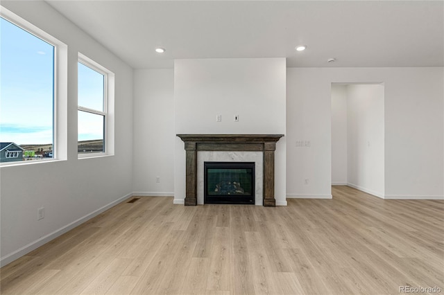 unfurnished living room with light hardwood / wood-style floors and a tile fireplace