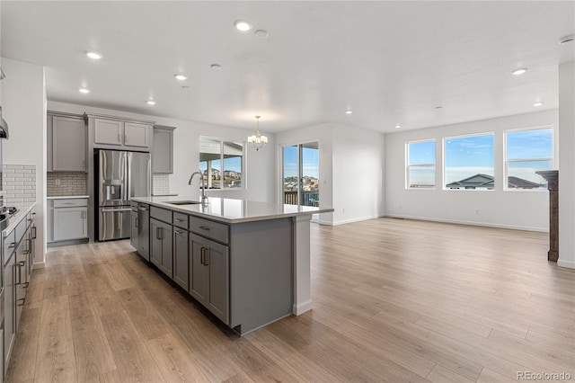 9314 Quartz St, Arvada, CO 80007 - kitchen featuring gray cabinets, a sink, appliances with stainless steel finishes, a chandelier, and light wood-style flooring