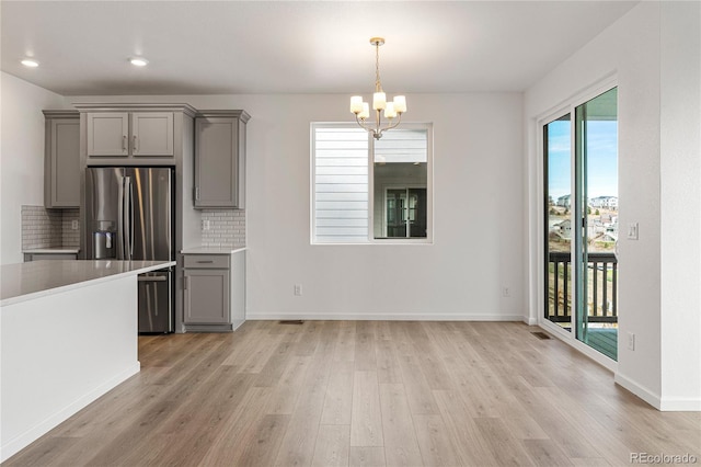 9314 Quartz St, Arvada, CO 80007 - kitchen featuring gray cabinetry, stainless steel fridge, light wood-style flooring, a chandelier, and recessed lighting