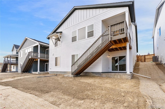 9314 Quartz St, Arvada, CO 80007 - back of house with stairway, central AC unit, board and batten siding, and a deck