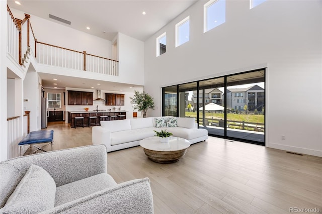6677 Crossbridge Cir, Castle Pines, CO 80108 - living room with a high ceiling, light wood-type flooring, and baseboards