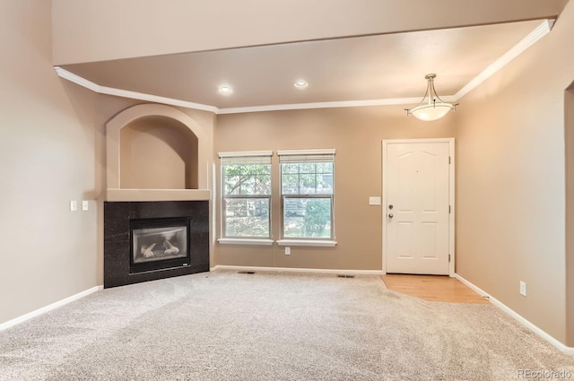 unfurnished living room featuring light colored carpet, crown molding, and a tile fireplace