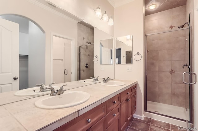 bathroom with ornamental molding, tile patterned floors, an enclosed shower, and vanity