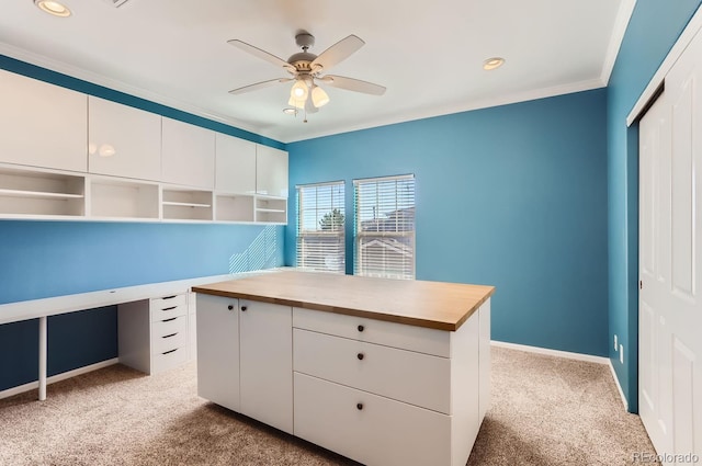 unfurnished office with ceiling fan, light colored carpet, and ornamental molding