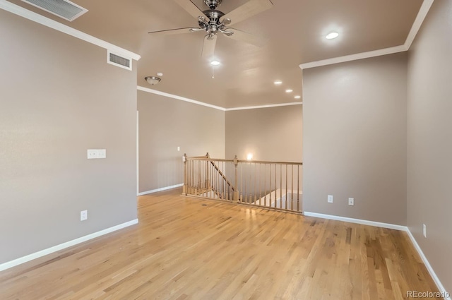 spare room with light wood-type flooring, ornamental molding, and ceiling fan