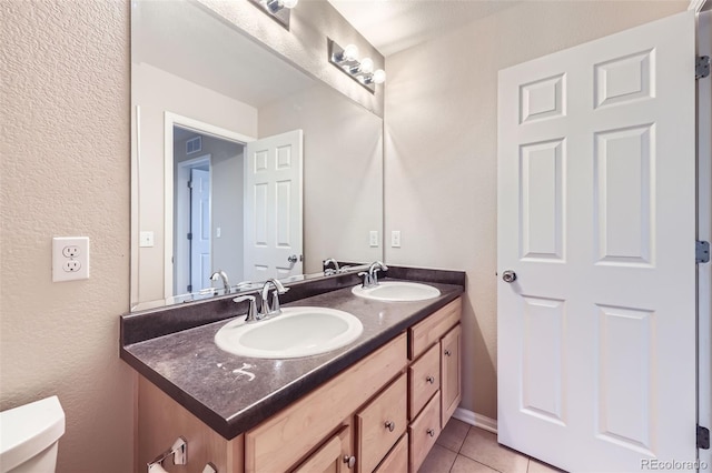 bathroom with toilet, tile patterned floors, and vanity