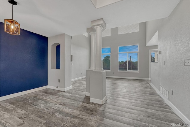 3630 Sawgrass Trl, Castle Rock, CO 80109 - spare room featuring ornate columns, a textured wall, wood finished floors, and baseboards