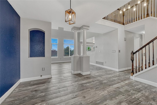 3630 Sawgrass Trl, Castle Rock, CO 80109 - empty room with wood finished floors, baseboards, decorative columns, and stairs