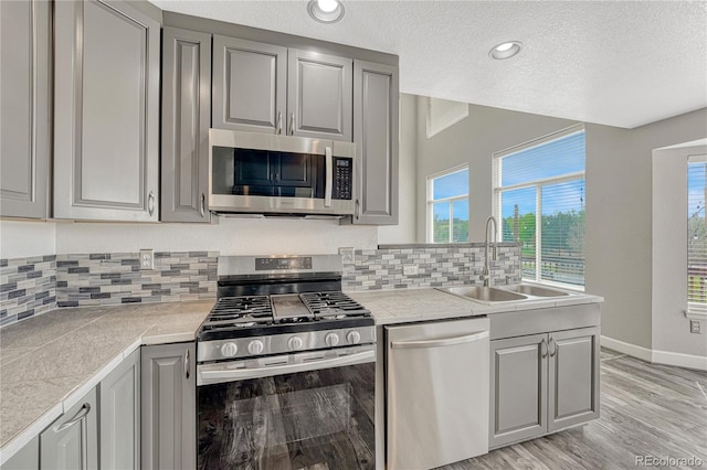 3630 Sawgrass Trl, Castle Rock, CO 80109 - kitchen featuring appliances with stainless steel finishes, gray cabinets, a sink, a textured ceiling, and recessed lighting