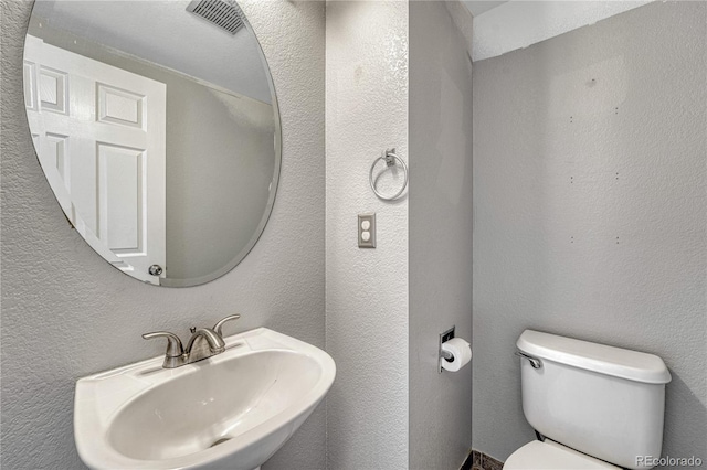 3630 Sawgrass Trl, Castle Rock, CO 80109 - half bathroom featuring a sink, toilet, and a textured wall