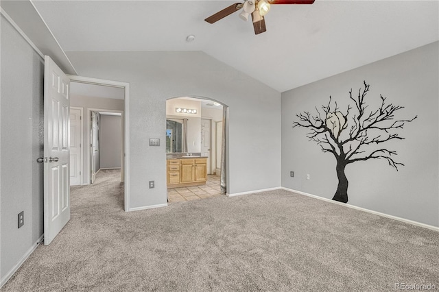3630 Sawgrass Trl, Castle Rock, CO 80109 - unfurnished bedroom featuring lofted ceiling, arched walkways, light colored carpet, ensuite bathroom, and baseboards