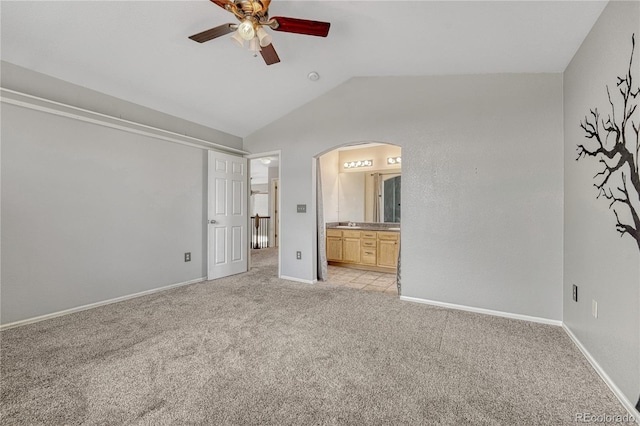 3630 Sawgrass Trl, Castle Rock, CO 80109 - unfurnished bedroom featuring arched walkways, lofted ceiling, light carpet, connected bathroom, and baseboards