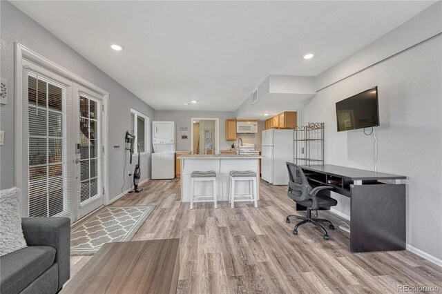3630 Sawgrass Trl, Castle Rock, CO 80109 - office area featuring stacked washer and clothes dryer, light wood finished floors, baseboards, a sink, and recessed lighting