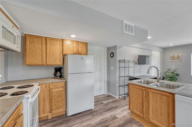 3630 Sawgrass Trl, Castle Rock, CO 80109 - kitchen with white appliances, a sink, light wood-style floors, light countertops, and recessed lighting