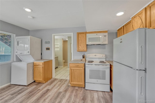 3630 Sawgrass Trl, Castle Rock, CO 80109 - kitchen featuring white appliances, stacked washer and clothes dryer, baseboards, light countertops, and light wood-style flooring