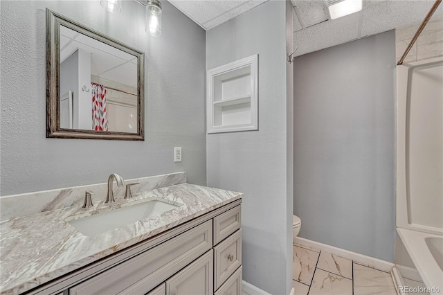 3630 Sawgrass Trl, Castle Rock, CO 80109 - full bath featuring vanity, marble look tile flooring, toilet, baseboards, and a paneled ceiling