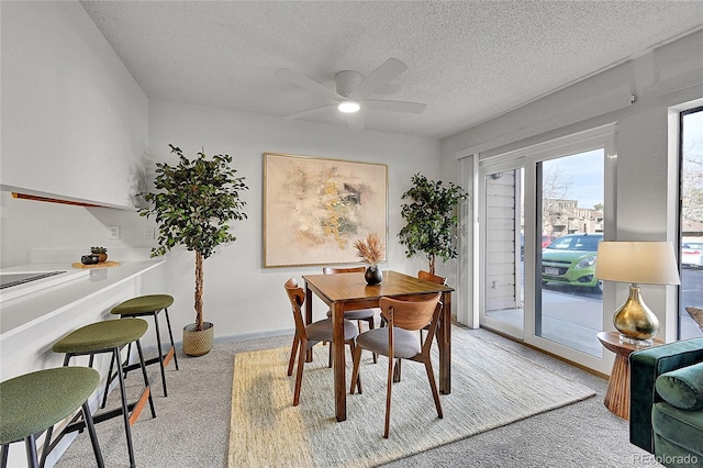 dining room with light carpet, a textured ceiling, and ceiling fan