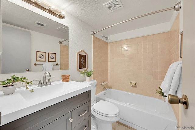 full bathroom featuring vanity, toilet, a textured ceiling, and tiled shower / bath