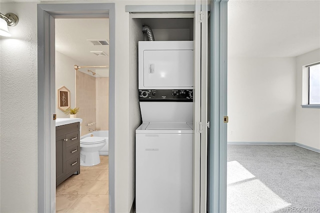 laundry area with light carpet and stacked washer and clothes dryer