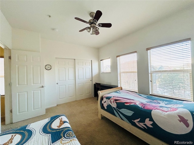 carpeted bedroom featuring ceiling fan and a closet