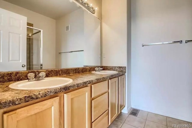 bathroom with vanity, a shower with door, and tile patterned floors