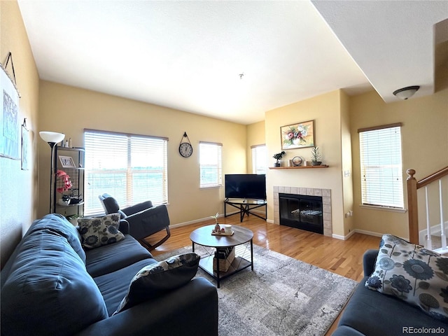 living room featuring wood-type flooring and a tile fireplace