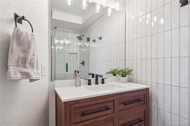 31607 Broadmoor Dr, Evergreen, CO 80439 - bathroom featuring vanity, a shower stall, a textured wall, and tile walls