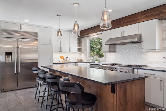 31607 Broadmoor Dr, Evergreen, CO 80439 - kitchen with stainless steel built in refrigerator, under cabinet range hood, open shelves, a kitchen island, and backsplash