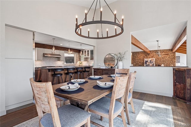 31607 Broadmoor Dr, Evergreen, CO 80439 - dining space featuring a chandelier, wood finished floors, beamed ceiling, and a high ceiling