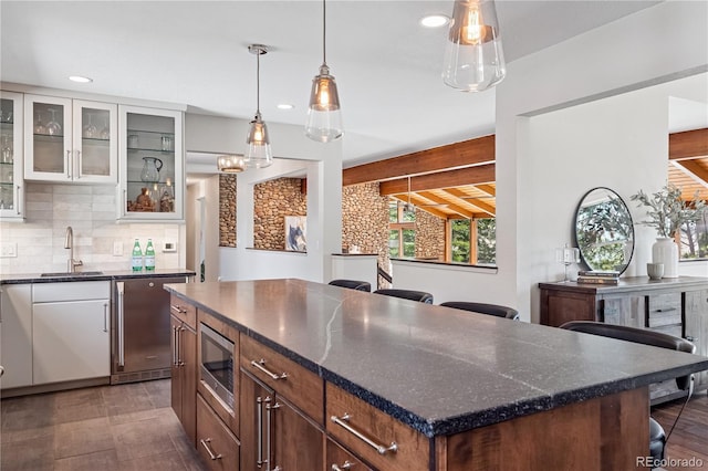 31607 Broadmoor Dr, Evergreen, CO 80439 - kitchen featuring stainless steel microwave, a sink, recessed lighting, backsplash, and glass insert cabinets