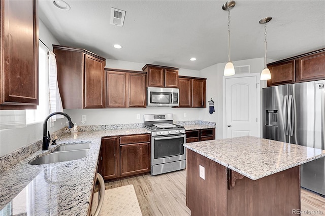10684 Calista Way, Fountain, CO 80817 - kitchen featuring appliances with stainless steel finishes, light stone countertops, light wood-type flooring, a center island, and recessed lighting