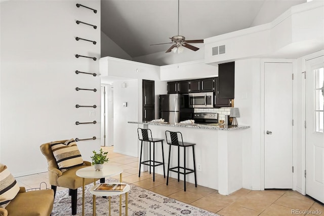 kitchen with stainless steel appliances, visible vents, dark cabinets, and light tile patterned floors