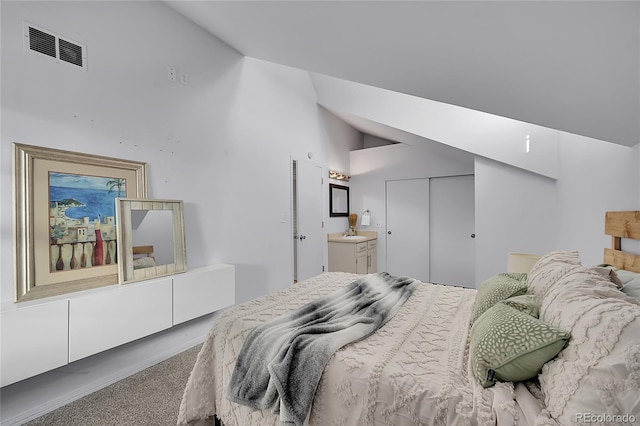 bedroom featuring lofted ceiling, connected bathroom, carpet flooring, visible vents, and a closet