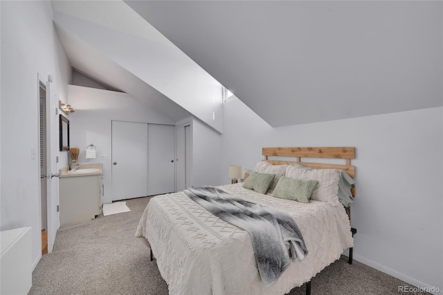 carpeted bedroom with a closet, vaulted ceiling, and baseboards