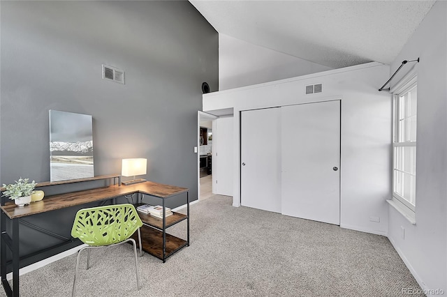 office space featuring lofted ceiling, carpet flooring, visible vents, and baseboards