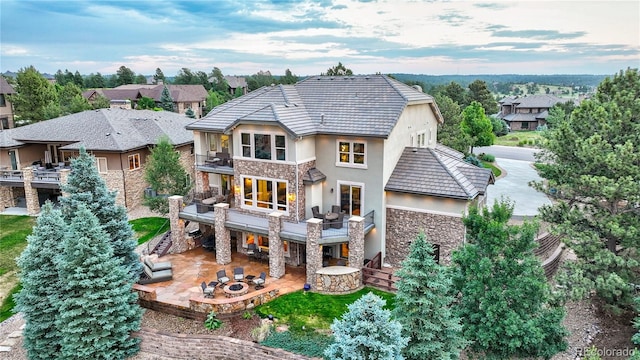 back of house featuring a balcony and a patio area