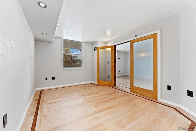 empty room featuring french doors and hardwood / wood-style floors