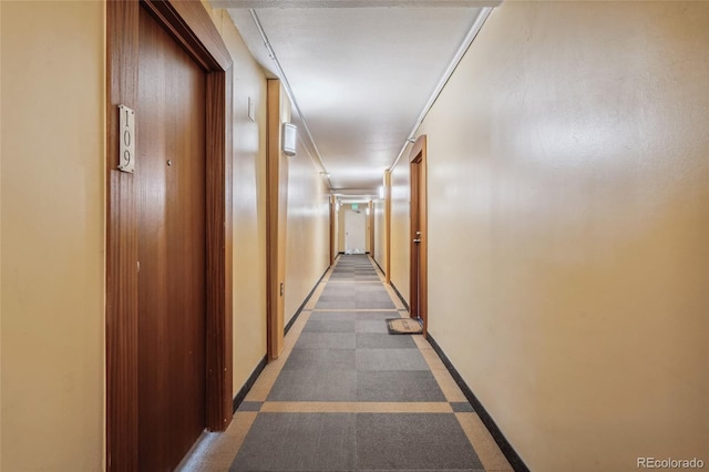 hallway featuring carpet floors and baseboards
