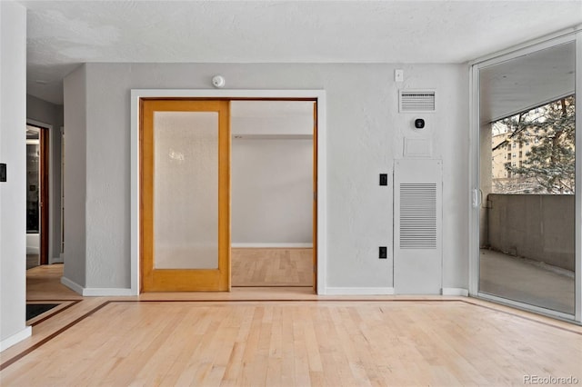 interior space with baseboards, wood-type flooring, a closet, and visible vents