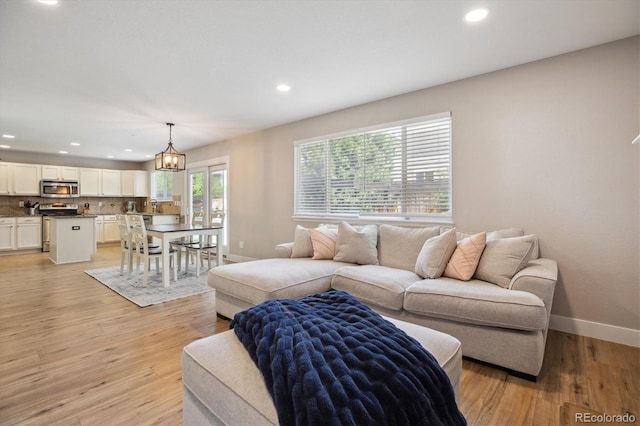 living area featuring recessed lighting, baseboards, and light wood finished floors